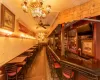 Bar with ceiling fan with notable chandelier and pendant lighting