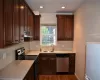 Kitchen with sink, dark hardwood / wood-style flooring, stainless steel appliances, and tasteful backsplash