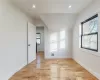 Unfurnished room featuring lofted ceiling and light hardwood / wood-style flooring