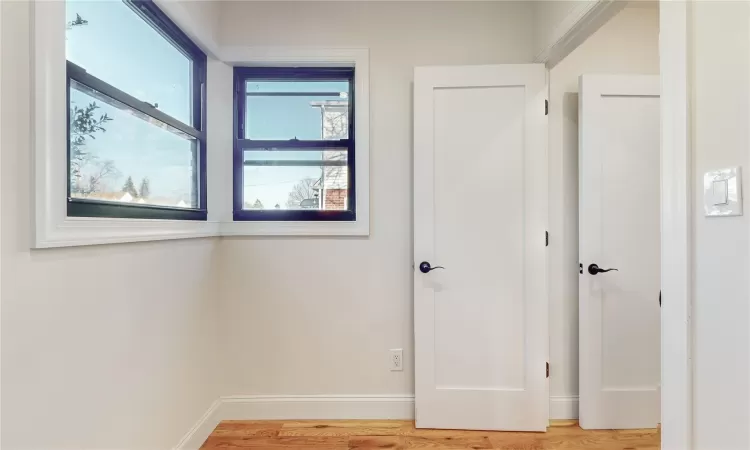 Corridor with hardwood / wood-style floors