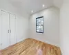 Unfurnished bedroom featuring light hardwood / wood-style floors, a closet, and vaulted ceiling