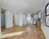 Kitchen with tasteful backsplash, stainless steel appliances, sink, light hardwood / wood-style flooring, and white cabinets