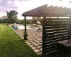 Pool/yard at dusk with a patio area and a pergola