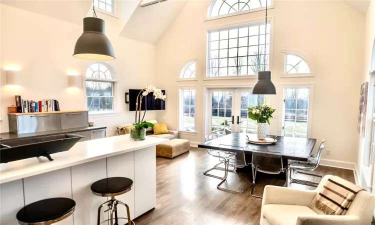 Dining space featuring a high ceiling, french doors, and wood-type flooring