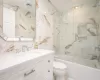 Full bathroom featuring crown molding, toilet, shower / bath combination with glass door, vanity, and tile walls