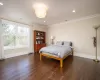 Bedroom with crown molding and dark wood-type flooring