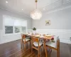 Dining area with dark hardwood / wood-style flooring, an inviting chandelier, and ornamental molding