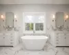 Bathroom with a tub to relax in, vanity, and tile walls