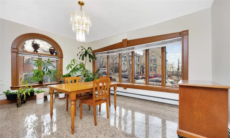 Dining room with a baseboard heating unit and a notable chandelier