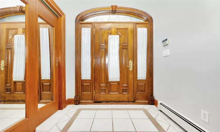 Tiled foyer entrance featuring baseboard heating