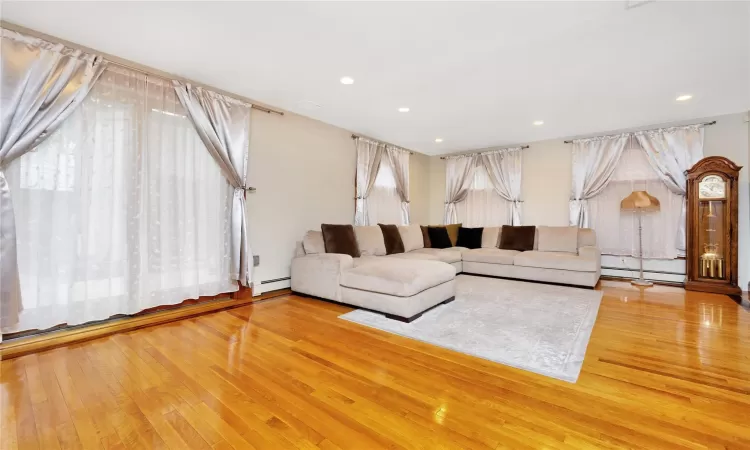 Living room with a baseboard radiator and hardwood / wood-style floors