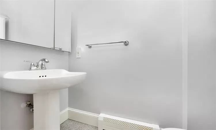 Bathroom featuring sink and a baseboard heating unit