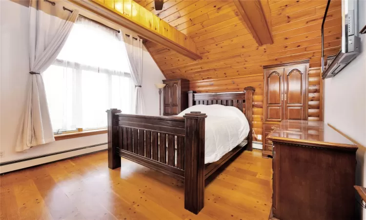 Bedroom with a baseboard heating unit, light hardwood / wood-style flooring, wood ceiling, and vaulted ceiling with beams