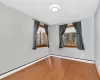 Spare room featuring baseboard heating and hardwood / wood-style floors