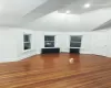 Unfurnished living room featuring lofted ceiling, wood-type flooring, and radiator heating unit