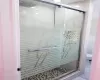 Bathroom with tile patterned floors, toilet, and an enclosed shower