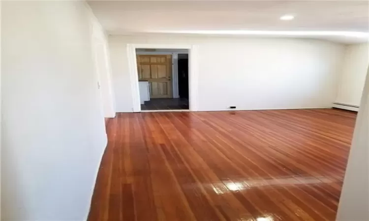 Bedroom room featuring dark wood-type flooring and a baseboard heating unit