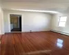 Unfurnished room with a baseboard heating unit and dark hardwood / wood-style flooring