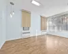 Unfurnished living room featuring radiator heating unit, ornamental molding, and hardwood / wood-style floors