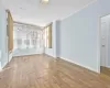 Spare room with wood-type flooring and crown molding