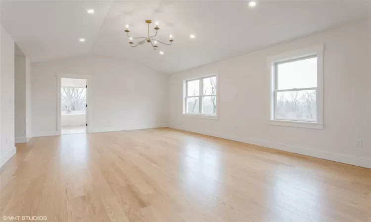 Oversized primary bedroom with vaulted ceilings and two walk in closets