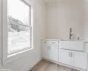 laundry room with custom cabinetry and farm sink