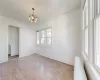 Empty room featuring a chandelier and hardwood / wood-style floors