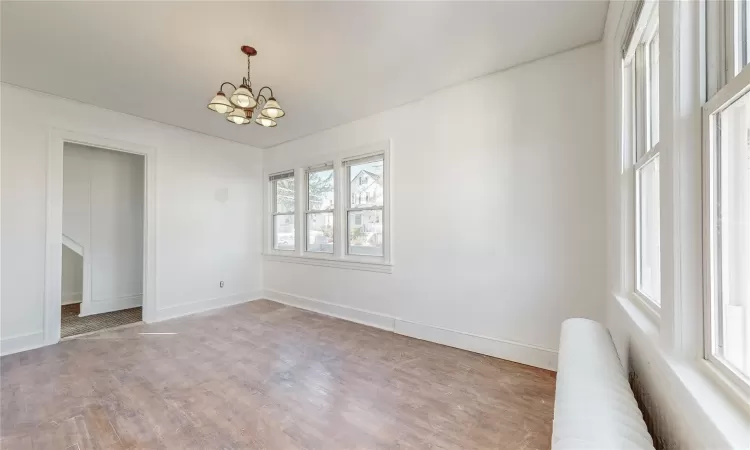 Empty room featuring a chandelier and hardwood / wood-style floors