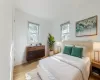 Bedroom featuring multiple windows and light hardwood / wood-style flooring