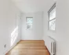 Unfurnished room with radiator, plenty of natural light, and light hardwood / wood-style floors