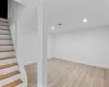 Basement with light hardwood / wood-style flooring