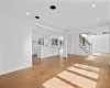 Staircase featuring a healthy amount of sunlight, a high ceiling, and hardwood / wood-style flooring