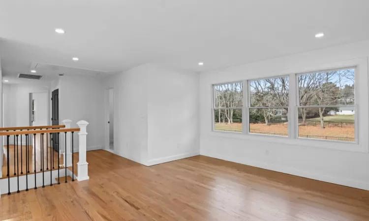 Kitchen featuring white cabinets, light wood-type flooring, and light stone countertops