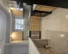 Kitchen featuring sink, dishwashing machine, range, and light tile patterned flooring