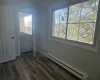 Entryway featuring baseboard heating, dark hardwood / wood-style floors, and ornamental molding