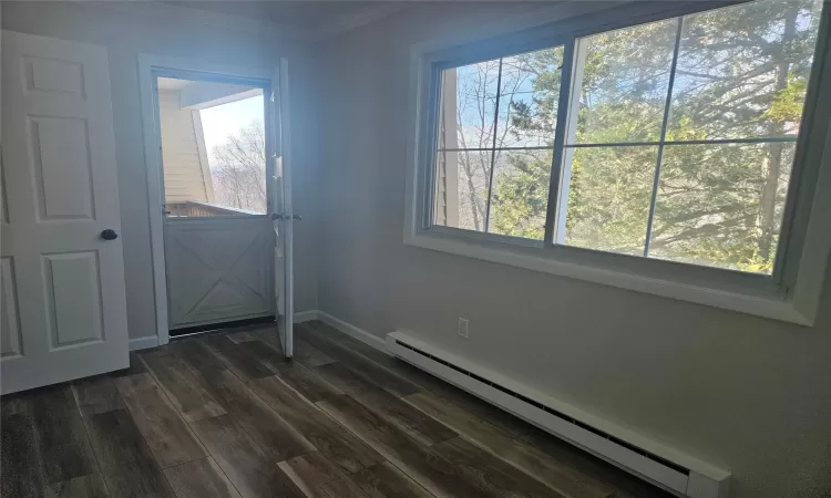 Entryway featuring baseboard heating, dark hardwood / wood-style floors, and ornamental molding