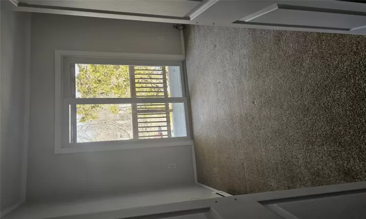 Carpeted empty room with a baseboard heating unit and ornamental molding