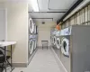 Washroom with washing machine and dryer and light tile patterned flooring