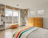 Bedroom with baseboard heating, light hardwood / wood-style flooring, and multiple windows