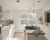 Kitchen featuring baseboard heating, appliances with stainless steel finishes, wooden counters, white cabinetry, and hanging light fixtures