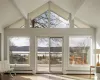 Doorway to outside featuring baseboard heating and vaulted ceiling with beams