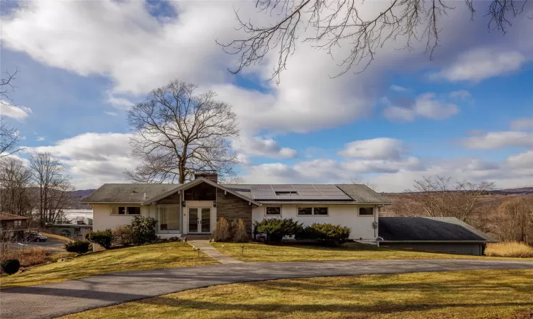 Single story home with a front lawn and solar panels