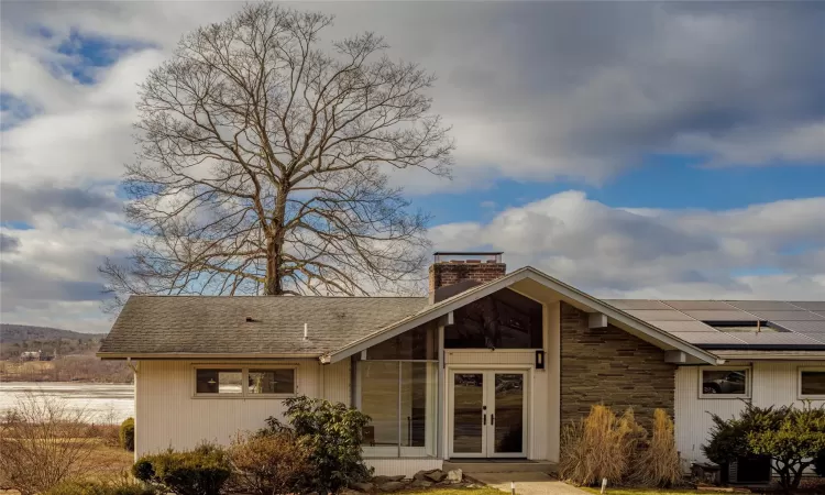 Back of house with french doors and solar panels