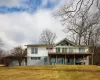 Rear view of property featuring a deck and a yard