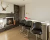 Bar featuring light hardwood / wood-style floors and a stone fireplace