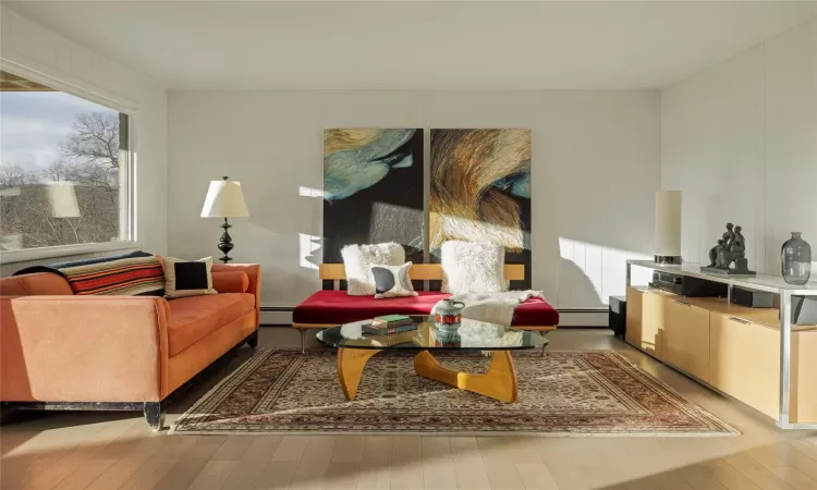 Sitting room featuring baseboard heating and light hardwood / wood-style floors