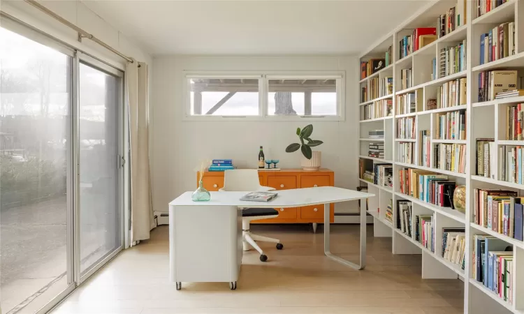 Office space with a baseboard radiator and light hardwood / wood-style flooring