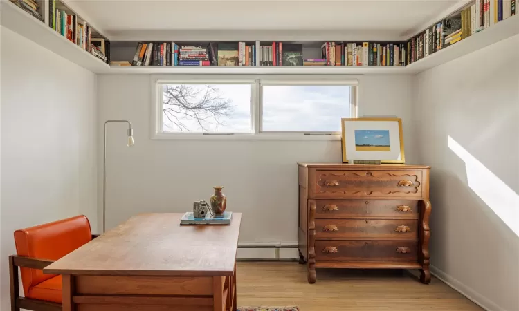 Office area with a baseboard heating unit and wood-type flooring