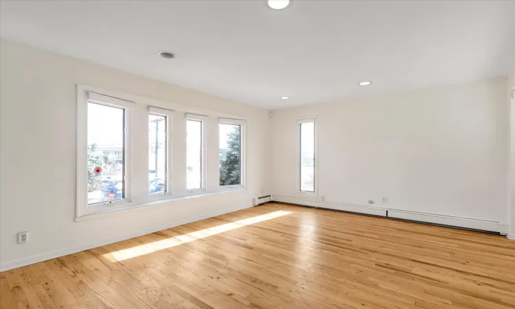 Empty room featuring light wood-type flooring and baseboard heating