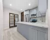 Kitchen with stainless steel appliances, sink, kitchen peninsula, light wood-type flooring, and gray cabinetry